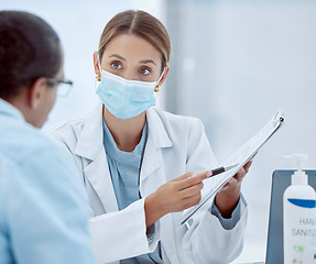 Image showing Covid, woman and doctor with documents for consulting, records or patient help at hospital. Female, health and healthcare mask physician, form for vaccine agreement and pandemic safety regulations.