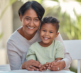 Image showing Senior grandma with young boy, smile in portrait together at table in garden at her house. Grandmother in retirement, happy to spend time with male grandchild outdoors at family home or on vacation