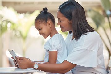 Image showing Mother, girl and tablet streaming cartoon, video or education game for children while sitting outdoor. Latin woman and her young daughter watching funny children movie online with technology