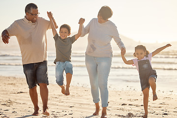 Image showing Happy, kids and grandparents with energy and jump playing at the beach on a fun family day at sea on holiday vacation together. Excited children bonding with their grandmother and grandfather outdoor