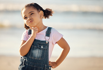 Image showing Thinking child, planning and in doubt at beach front on vacation in Mexico. Young girl learning independence, using imagination and ideas for fun play on travel to ocean or sea with cute face