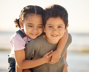 Image showing Children, kids and outdoor hug of boy and girl with a happiness in nature. Portrait of a happy smile of a young cute kid and child siblings smiling by the sea, ocean and beach hugging youth together