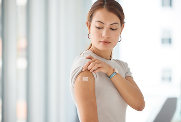 Image showing Woman with plaster on arm from covid vaccine, medical injection and corona virus cure for immune system, wellness and clinic healthcare. Asian female patient with bandaid, vaccination and flu risk