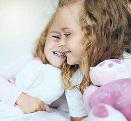 Image showing Children, love and twin sisters playing together holding teddy bear toys while lying comfortable sharing family or sibling bond at home. Happy, family and caring girls and friends in bed for fun