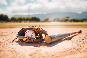 Image showing Baseball, sport and empty with a bat, ball and mitt on a base plate on a pitch outdoor after a competitive game. Fitness, sports and still life with exercise equipment on the ground for training