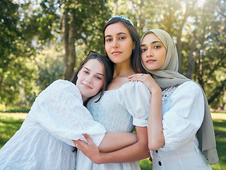 Image showing Group of women hug, show diversity, support and solidarity together, against forrest or garden background. Multicultural friends stand in unity, in outdoor portrait with trees or woods in backdrop