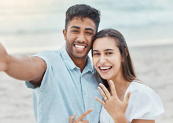 Image showing Couple selfie, engagement proposal or wedding ring at the beach, jewelry or engaged announcement. Romance face portrait, love and commitment of man and woman by the ocean celebrating with a smile.