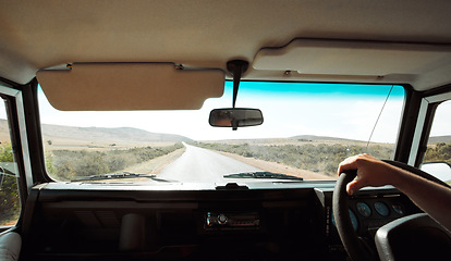 Image showing Road trip, car and travel with hand driving in countryside for transportation, adventure or road safety. Motor van driver on asphalt nature journey with dashboard, steering wheel and windshield pov