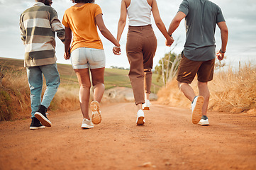 Image showing Friends, walking and holding hands with a man and woman friend group taking a walk outside in nature or the dessert. Trust, support and vacation with people in the wilderness for travel and tourism