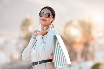 Image showing Retail shopping bag, urban woman and portrait travel for discount sales, market and outdoor sun in Dubai. Happy rich arab customer, consumer and wealthy person with sunglasses buying luxury fashion