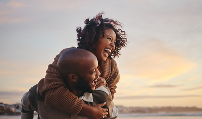 Image showing Black couple, travel and beach fun while laughing on sunset nature adventure and summer vacation or honeymoon with a piggy back ride. Comic, energy and black man and woman love on ocean holiday