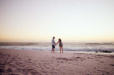 Image showing Beach, sunset and couple holding hands on date in summer, outdoor holiday or vacation with sand and sky mockup. Love, care and travel with affection people walking by sea, horizon mock up background