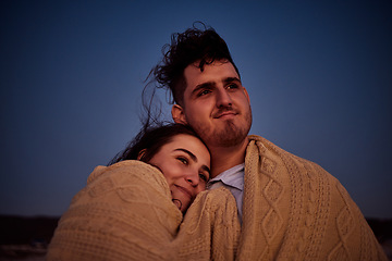 Image showing Love, blanket and couple watching a sunset, bonding and embracing in nature together, cozy and loving. Travel, romance and man and woman hug, taking a break to enjoy the view while on holiday