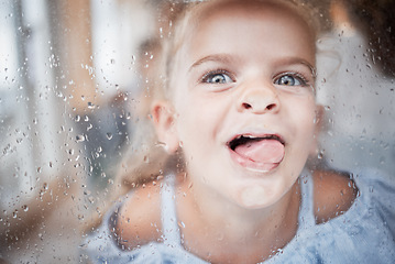 Image showing Funny, kid and tongue on window portrait with goofy and enthusiastic face pressed on surface. Young, happy and crazy girl child enjoying playful lick on glass with rain droplets closeup.