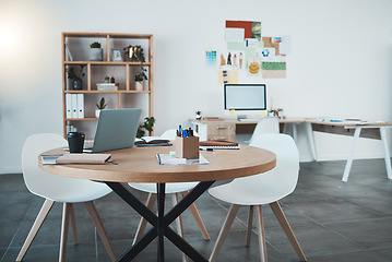 Image showing Empty office, laptop and documents in digital marketing space, advertising startup or creative small business. Furniture, technology and paper research in design workplace with table, desk and chairs