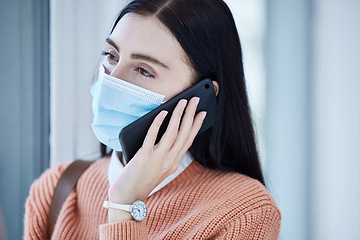 Image showing Woman, covid and mask on a phone call by window looking out at home for safety and quarantine indoors. Young female wearing protective face masks during pandemic and calling consultant on smartphone