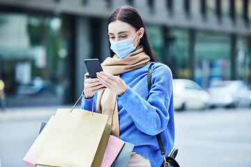 Image showing Woman, shopping in covid mask with smartphone, communication about sale or discount at retail mall. Young shopper in pandemic, bags and contact car service for travel and buyer with urban background.