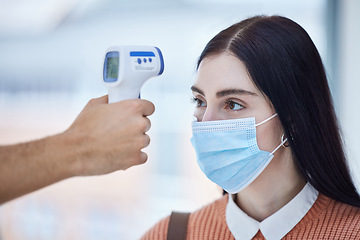 Image showing Thermometer, healthcare and covid with a doctor scan a patient temperature with infrared, checking for a fever. Sick woman with mask for corona, flu or cold in exam or consult in a medical clinic