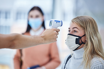 Image showing Covid, travel and safety thermometer security test at airport for healthcare protocol inspection. Travelling woman with face mask for coronavirus fever check with medical screening worker.