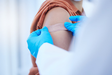 Image showing Doctor hand, covid vaccine and plaster on patient for virus protection or illness prevention. Medical professional, health care worker and place bandage on arm wound after vaccination injection