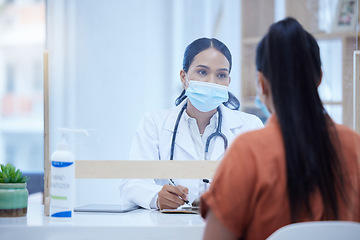 Image showing Covid, consulting and doctor and woman at desk and glass window for help, medical and therapy in clinic. Safety, medicine and checklist with patient and healthcare professional in counseling room