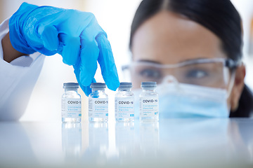 Image showing Doctor, vaccine and covid 19 in lab, hospital or clinic for safety, health and wellness against virus. Woman, medic and ppe at work in science for vaccination, healthcare and cure for coronavirus