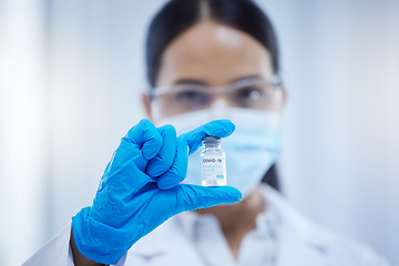 Image showing Covid, innovation and woman scientist with the vaccine or virus cure in a medical laboratory after research analysis. Face mask, safety and healthcare science doctor holding antivirus medicine