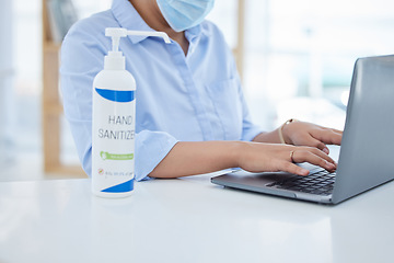Image showing Covid, hand sanitizer and a woman in office typing on laptop with face mask. Online work, hygiene and businesswoman with alcohol spray on desk. Virus prevention, safety and cleaning hands in pandemic