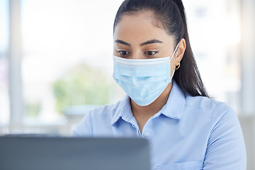 Image showing Covid, laptop and business woman typing an email on the internet in office at work. Corporate manager, employee or worker reading a proposal and working on the internet at a company with a face mask