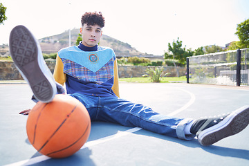 Image showing Basketball, fashion and portrait of a trendy model sitting on the floor of outdoor court. Edgy, stylish and cool man or influencer with a sports ball relaxing on outside sport field in the urban city