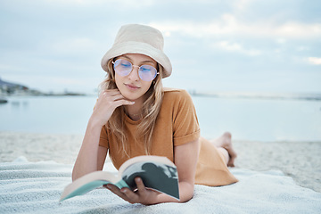 Image showing Beach, relax and woman reading a book in peaceful summer holidays or vacation outdoors in nature with freedom. Travel, ocean and young girl enjoying quality time alone, break and calm resting trip