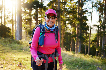 Image showing Hiking, nature and summer with a senior woman in the forest or woods, walking for health and exercise. Trees, fitness and hike with an elderly female pensioner taking a walk in the mountain in summer