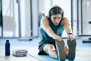 Image showing Pilates, yoga and man stretching at gym for training or fitness exercise and streaming audio, music playlist or radio. Wellness, healthy and young athlete listening to podcast before starting cardio