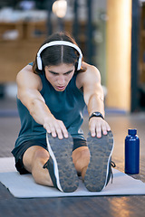 Image showing Man, music headphones or stretching on mat in gym workout, training or exercise for wellness, health or cardio. Personal trainer, sports and fitness person listening motivation radio podcast on break