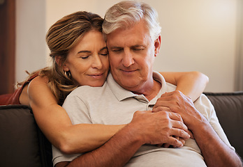 Image showing Hug, love and senior couple giving support during retirement in the living room of their house. Happy elderly man and woman hugging in trust, help on sofa and happiness together in their home