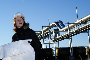 Image showing Young architect looking at blueprint in front of construction si