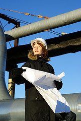 Image showing Young architect looking at blueprint in front of construction si