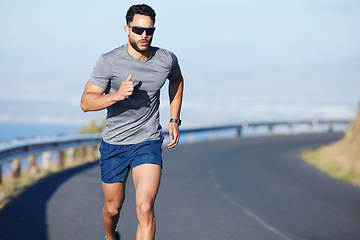 Image showing Training, exercise and man running on road in city in summer with ocean background. Fitness, sports and runner with watch on the mountain in South Africa. Exercising, cardio and workout for athlete