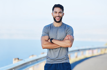 Image showing Man athlete, healthy and with cross arms, smile and stand happy outdoor for workout, warm up and wellness..Portrait, confident male and trainer ready for training, fitness and enjoy health exercise.