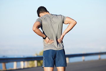 Image showing Fitness, tired and man with back pain in city while training cardio, marathon and health. Athlete runner with medical emergency for body while running, doing sports exercise and workout in the street