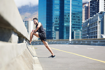 Image showing Fitness, exercise and stretching with a sports man or runner warming for a training workout in the city. Running, health and wellness with a male athlete at the start of his performance routine