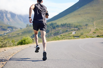 Image showing Running, fitness and exercise with a sports man and runner outdoor on a road in nature for training. Workout, marathon and health with a male athlete on a run for sport on a road in the mountains