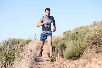 Image showing Fitness, mountain and man running in nature for exercise, cardio health and body goal. Strong athlete runner with focus during workout and training for wellness on a path in the countryside