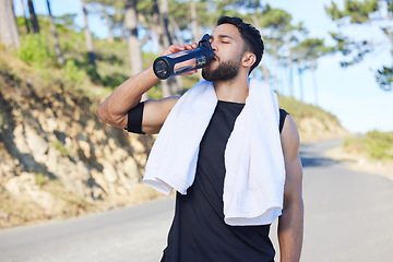 Image showing Water, fitness and exercise with a sports man drinking from a bottle for hydration during his workout or training routine. Health, wellness and rest with a male athlete taking a break from a routine