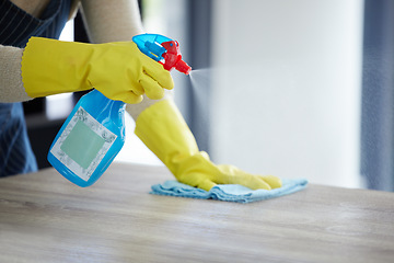 Image showing Hands, spray bottle or cleaning cloth on house, home or office wood desk or table in germs, virus or bacteria maintenance. Zoom, woman or housekeeping cleaner service with product container or gloves