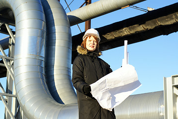 Image showing Young architect looking at blueprint in front of construction si