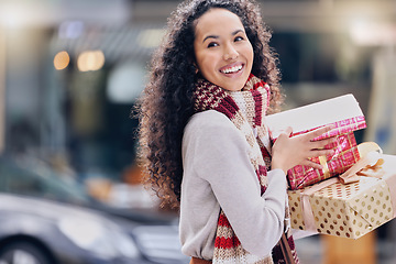 Image showing Shopping, christmas and retail with a black woman customer holding a gift or present outdoor in the city. Celebration, holiday and happy with a young female consumer at an outdoor mall or store