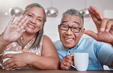 Image showing Senior couple, coffee and wave for video call smiling, talking or speaking at home. Elderly man and woman greeting on social media or face time while enjoying a warm beverage indoors