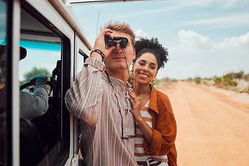 Image showing Road trip, travel and view with a couple using binoculars for sightseeing while outdoor on sand road during their summer vacation. Diversity, love and holiday with a man and woman traveling on a trip