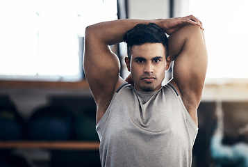 Image showing Health, young man stretching and wellness training in gym for workout, fitness and cardio. Portrait, Indian male or athlete confident, bodybuilding or doing healthy warm up for exercise in sportswear